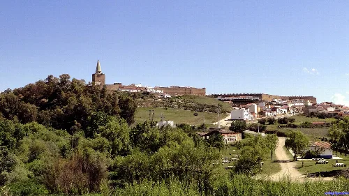 Landschaft mit Kirche und Häusern auf dem Hügel in Galisteo, Cáceres.