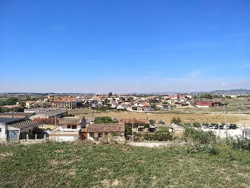 Vista panorámica de Beire con casas y campo bajo un cielo azul.