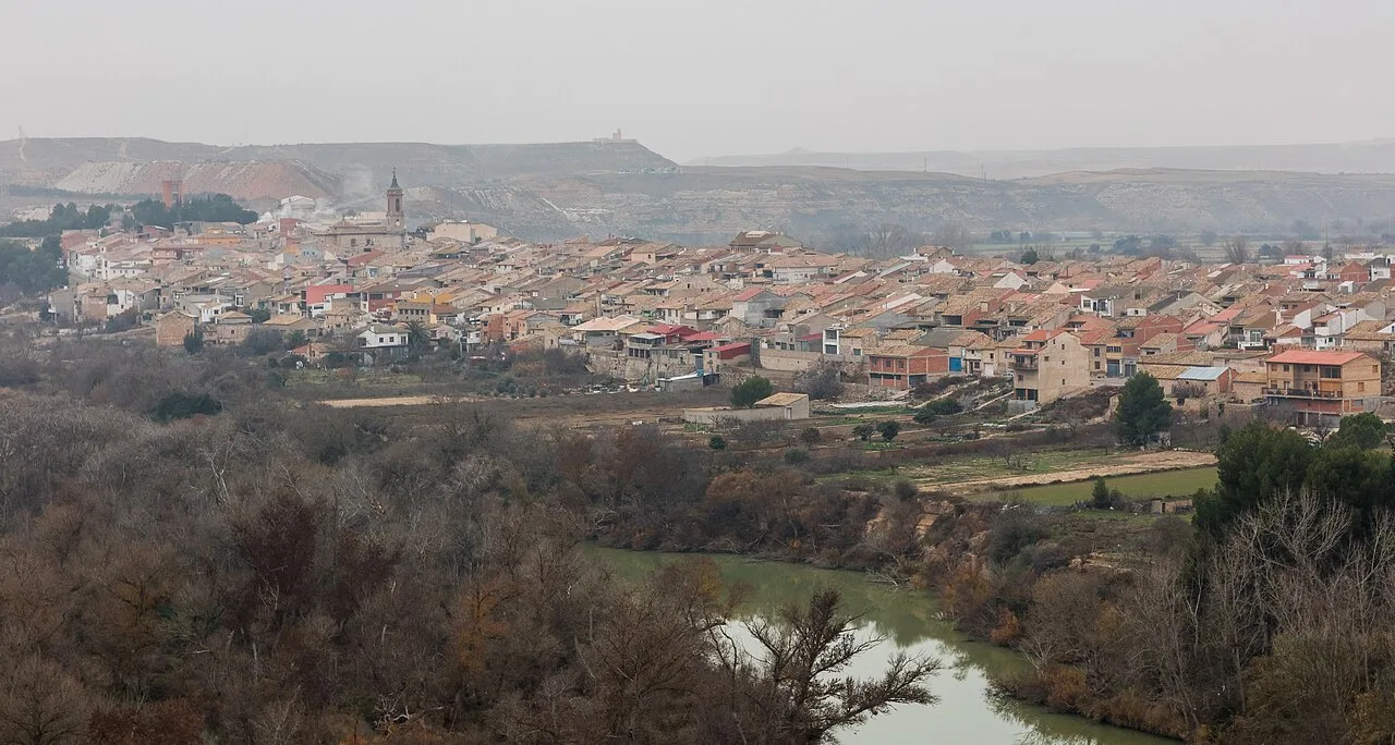 Vista panorámica de un pueblo con casas y colinas en el fondo.