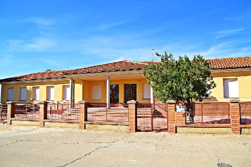 Schulgebäude mit Ziegelmauer und Eingangstür in Pinilla de Toro