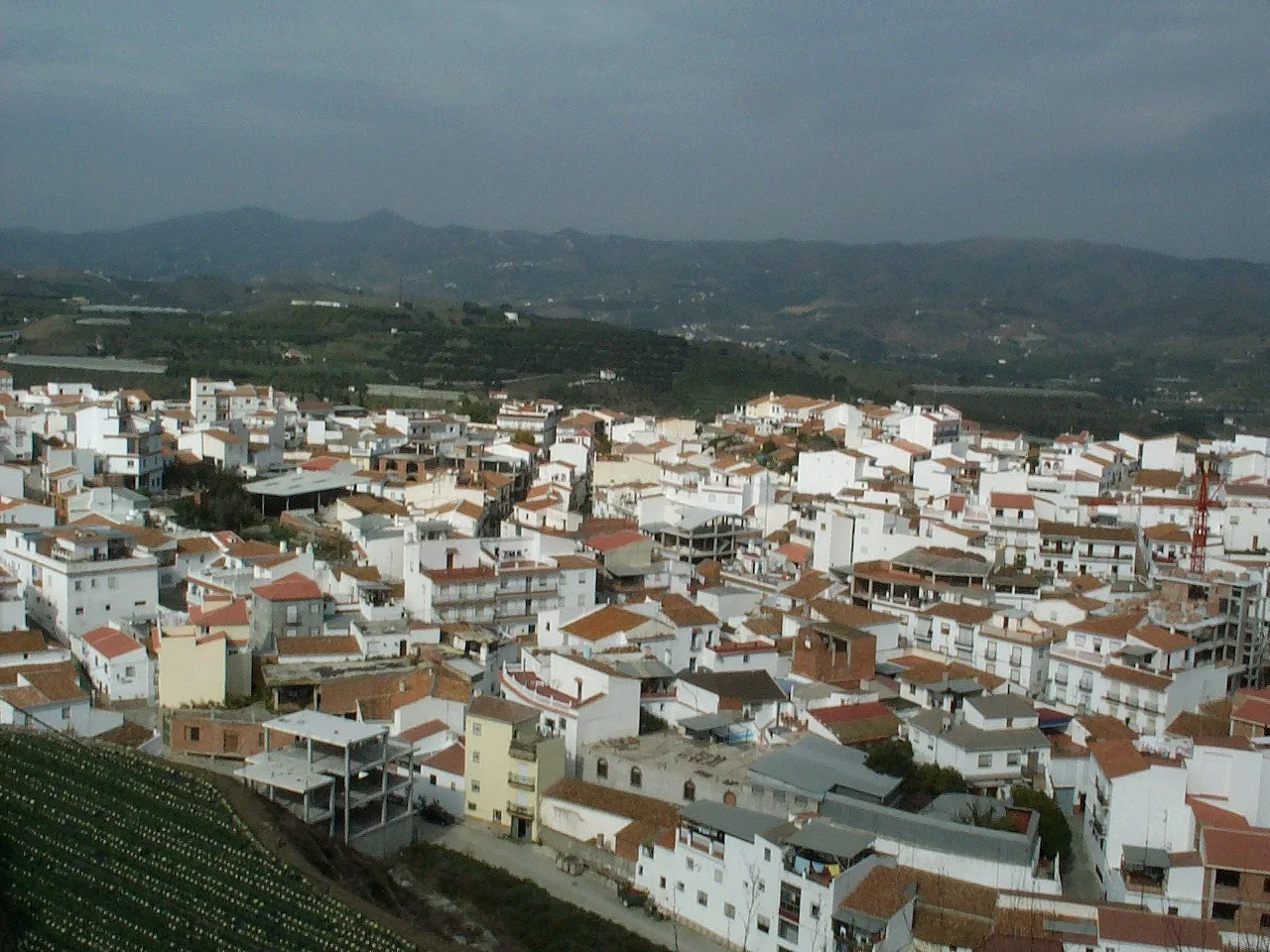 Vista de casas blancas y colinas verdes desde un mirador en Benamocarra.