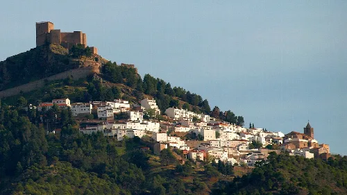 Aussicht auf eine Hügelstadt mit Burg und weißen Häusern.