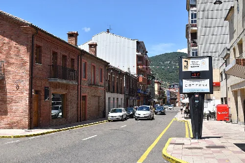 Avenida da Constitución mit Gebäuden und Autos in Cistierna.
