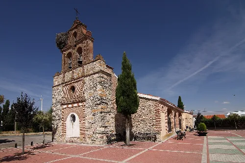 Iglesia de ladrillo con torre y cruz en Garcihernández.