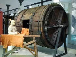 Large wooden drum at the Leather Museum of Igualada, with a woman figure and hides on display.