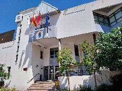 White building with flags and stairs at the entrance.