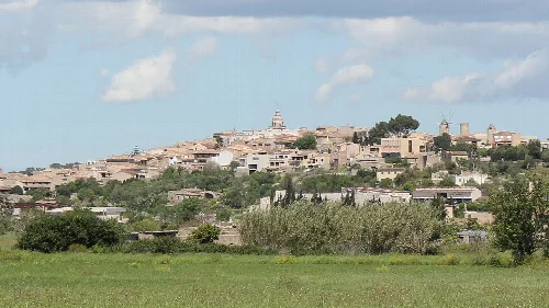 Blick auf Montuïri mit Häusern und einer Kirche auf dem Hügel.