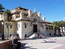 Facade of Cieza Food Market with ornamental details and palm trees in the square.