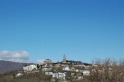 Vista de Puebla de Sanabria con casas blancas y una iglesia en la cima.