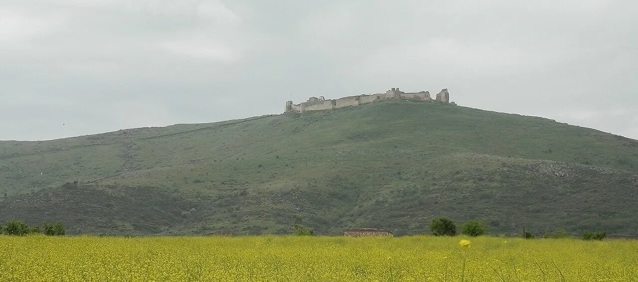 Vista de la alcazaba en la cima de una colina con cielo nublado.