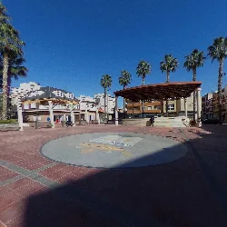 Music kiosk in Plaza de España in Rafal with palm trees and buildings.