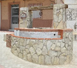 Restaurierter Brunnen mit Stein- und Holzstruktur in Benitagla.