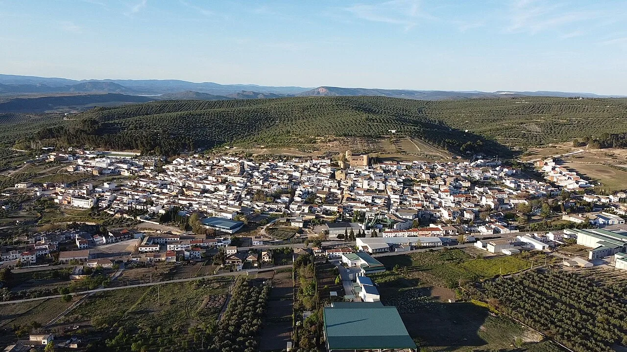 Aerial view of Canena with houses and green fields.