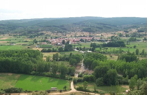 Ländliche Landschaft mit Bäumen, Wegen und Häusern in Santa Colomba de Curueño.