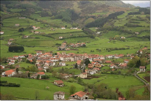 Landschaft von Berastegi mit Häusern und grünen Hügeln.