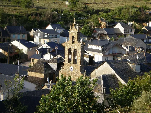 Luftaufnahme eines Dorfes mit Kirche und Häusern in ländlicher Umgebung.