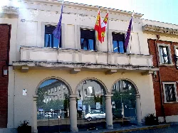 Town hall building with three flags on the facade.