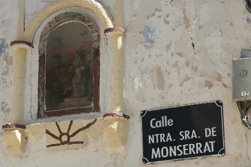 Old window with decoration and street sign in Codo, Zaragoza.