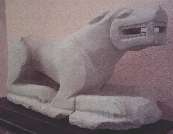 Iberische Skulptur eines liegenden Löwen mit offenem Mund und bedrohlicher Haltung.