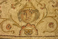 Roman mosaic with a human face and geometric patterns in Écija, Seville.