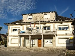 Town hall building of Taboada with flags on the facade.