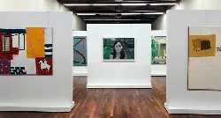 Galería de arte con pinturas y una escultura en exhibición