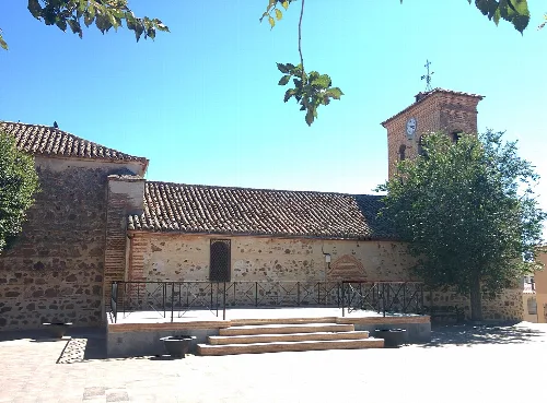 San Juan Bautista church in Marjaliza, Toledo, with tower and stone facade.