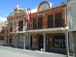 Backsteingebäude mit Flaggen und einer Uhr oben.