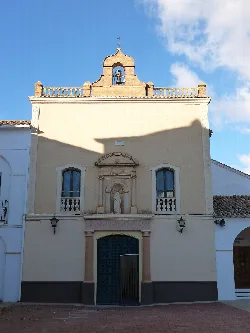 Facade of a monument with clock and figure in Almansa.
