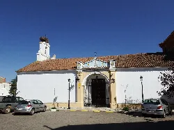 weiße Kirchenfassade mit eisernem Tor und Glockenturm in Agudo, Ciudad Real