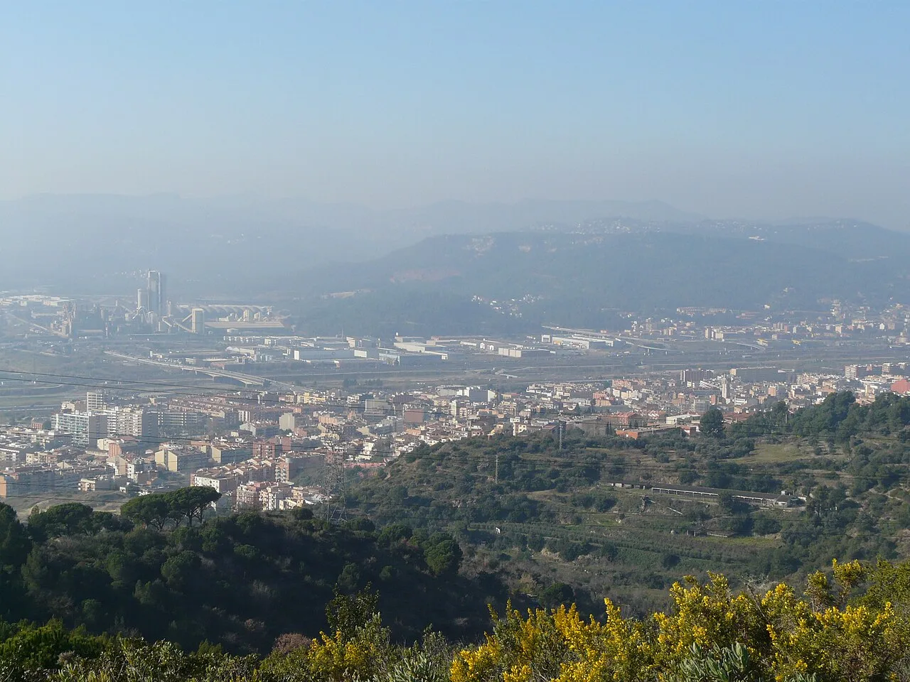 Landscape with city and mountains in the background.