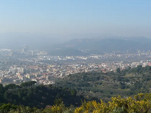 Landschaft mit Stadt und Bergen im Hintergrund.