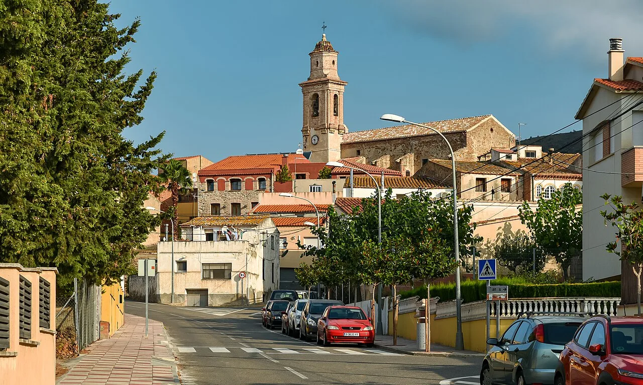 Calles de Botarell con casas y una torre de iglesia en el fondo.
