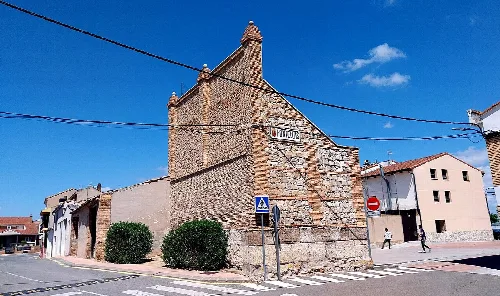 Edificio de piedra en Fontellas, Navarra, con cartel y paso de peatones.