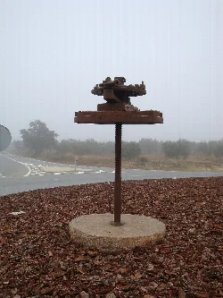 Prensa antigua de mosto en un entorno rural con niebla.