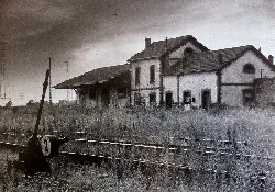 Old train station building in Peñarroya with tracks and signal in foreground.