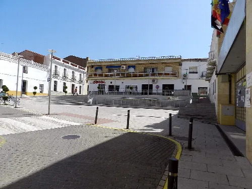 Plaza de España with white buildings and pedestrian zone in Casas de Don Pedro.