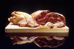 Carnes de pollo, cerdo y res en una tabla de cortar.