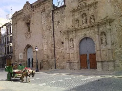 Carro en la plaza mayor de Algemesí con edificios antiguos.