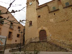 Iglesia de San Lorenzo Mártir en Botarell, Tarragona, con escaleras y muro de piedra.