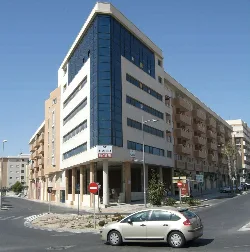Building with glass facade and balconies at the entrance of Vícar.
