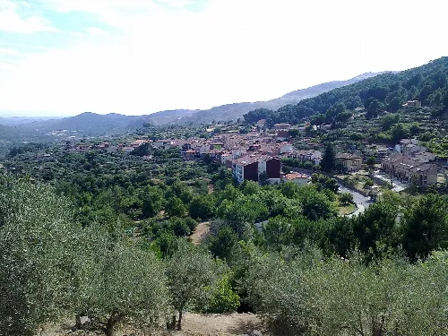 Blick auf Villarejo del Valle mit Bergen und Bäumen.