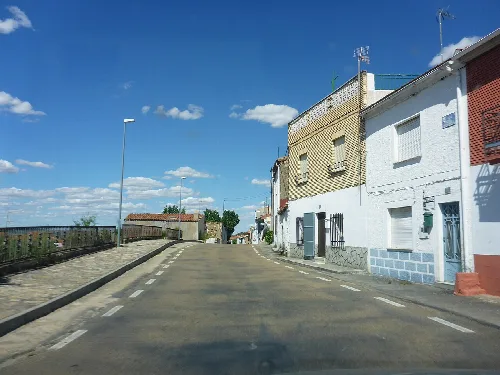 Street in Villarino de los Aires with white houses and blue sky.