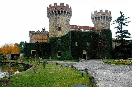 Schloss mit runden Türmen und bewachsenen Mauern in Perelada.