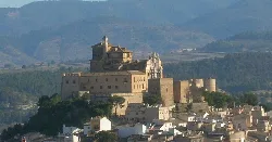 Castle and sanctuary in Caravaca de la Cruz with mountains behind.