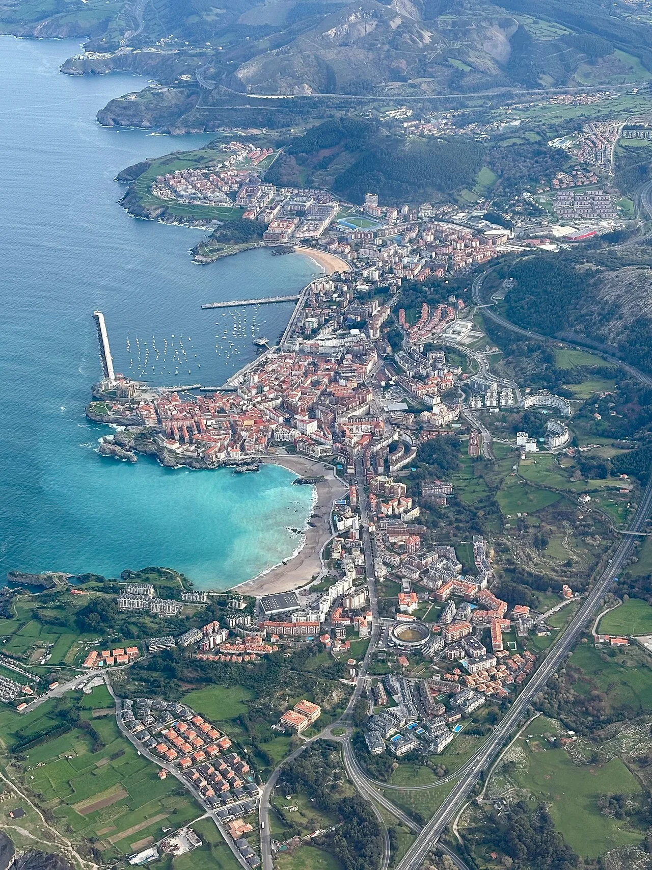Luftaufnahme von Castro-Urdiales mit Hafen, Strand und Gebäuden.