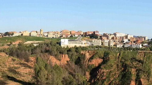 Panoramic view of Castellbisbal with buildings and nature.