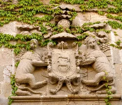 Escudo heráldico tallado en piedra en la fachada de la Casa Azkarraga.