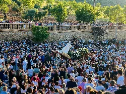 Multitud de personas en la romería con el Cristo en el centro.