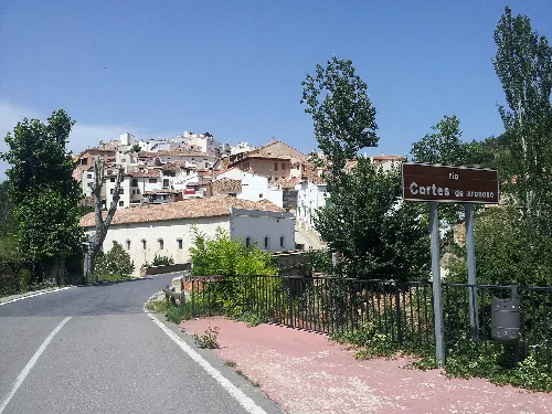 Road with river sign and houses on the hill in Cortes de Arenoso.